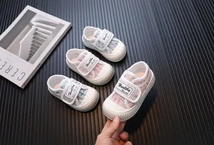 Détail des chaussures en toile pour tout-petits en tweed avec bride velcro pour bébés.