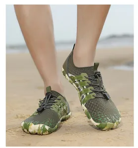 Close-up actieopname van camouflage waterschoenen voor kinderen gedragen op een zandstrand