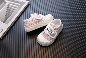 Gros plan de chaussures en tweed rose pour tout-petits avec semelles en caoutchouc blanc.