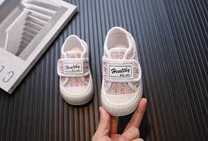 Gros plan sur une chaussure en tweed rose pour enfant avec fermeture à velcro
