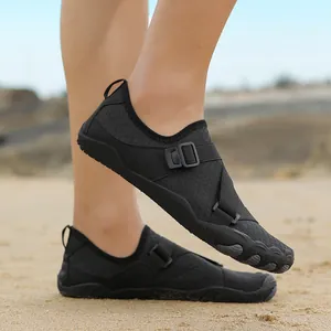 Non-slip black aqua shoes for swimming and outdoor wading on a sunny sandy beach
