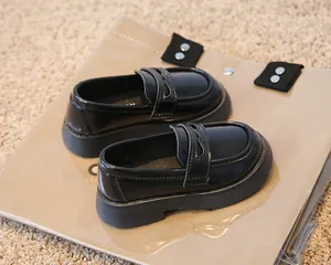 Vue détaillée des mocassins noirs brillants pour enfants de style britannique à semelle.