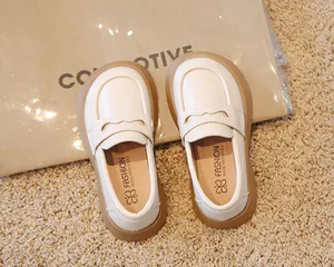 Vue de dessus de mocassins en cuir crème pour enfants avec semelles en caoutchouc