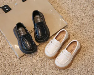 Vue détaillée de mocassins de style britannique pour enfants en noir et en beige