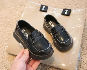 Vue détaillée des mocassins en cuir noir pour enfants avec motif ondulé élégant