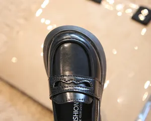 Gros plan de mocassins noirs de style britannique pour enfants à bout rond