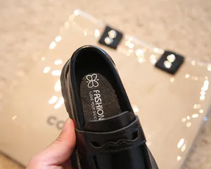 Vue macro de la semelle intérieure douce de marque dans un mocassin noir pour enfant