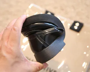 Gros plan montrant la flexibilité extrême et la semelle souple du mocassin enfant noir.