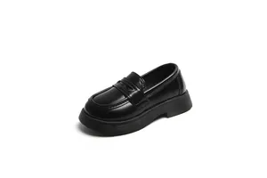 Gros plan sur un mocassin noir pour enfants style britannique à bout rond mixte