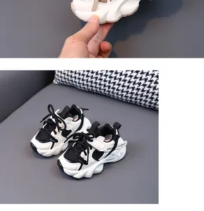 Vistas detalladas de zapatillas chunky para niños en blanco y negro con malla transpirable