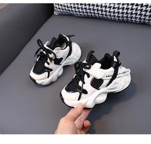 Vista lateral de zapatillas chunky para niños en blanco y negro con suela gruesa
