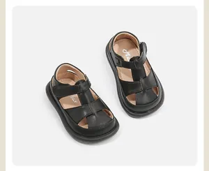 Nahaufnahme von schwarzen Lauflernschuhen aus Leder für Kleinkinder mit Klettriemen