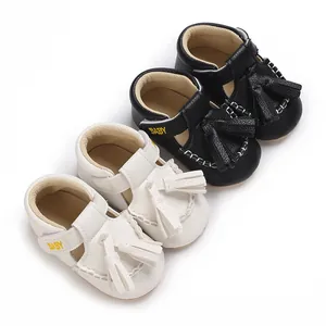 Detailansicht von Baby-Ledersandalen mit Quasten und gesticktem Baby-Schriftzug auf Riemen