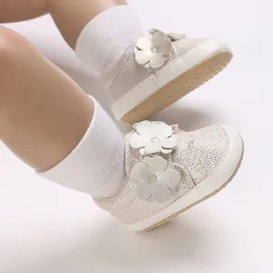 Gros plan de chaussures de marche scintillantes pour bébé avec fleurs en cuir
