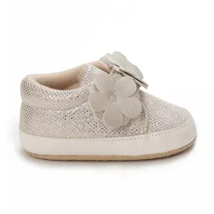 Vue détaillée d'une chaussure souple pour bébé scintillante avec décoration florale
