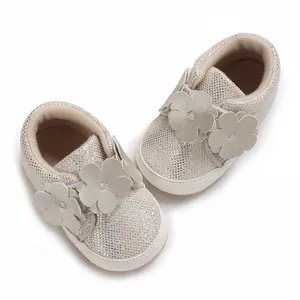 Vue de dessus de baskets pailletées pour bébé avec fleurs et semelles blanches souples