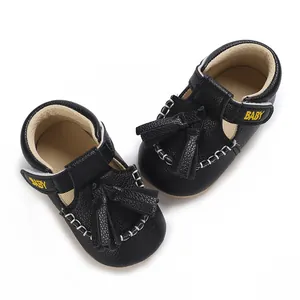 Detailansicht von oben auf schwarze Baby-Sandalen aus Kunstleder mit Fransen und Klettverschluss