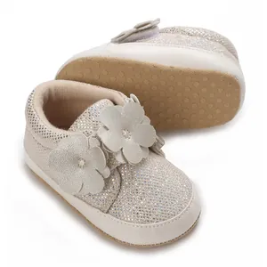 Vue détaillée de chaussures blanches scintillantes pour bébé avec fleurs et semelle souple