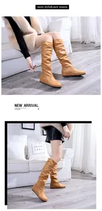 Gros plan détaillé de bottes hautes plissées marron avec talon compensé invisible.
