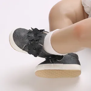 Gros plan de baskets noires pour bébé avec fleurs décoratives et semelles souples souples