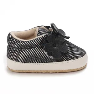 Détail de chaussures souples noires pour bébé avec paillettes et fleurs 3D décoratives