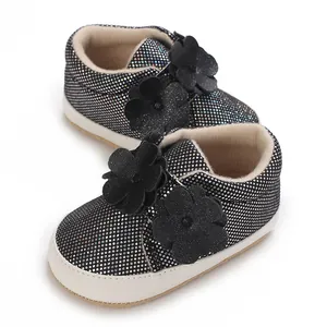 Gros plan détaillé de baskets noires scintillantes pour bébé avec doubles motifs floraux