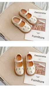 Detailansicht cremefarbener Mädchen-Mary-Janes mit Blumenstickerei und weicher Sohle
