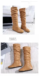 Détail de bottes plissées marron pour femme avec bout rond et texture cuir souple