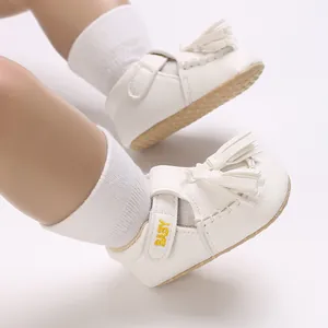 Detaillierte Ansicht weißer Baby-Ledersandalen mit Quasten und gelber Stickerei