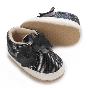 Gros plan sur des chaussures pour bébé à semelle souple avec paillettes noires