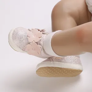 Détail de chaussures de marche souples roses pour bébé avec fleurs et semelle antidérapante