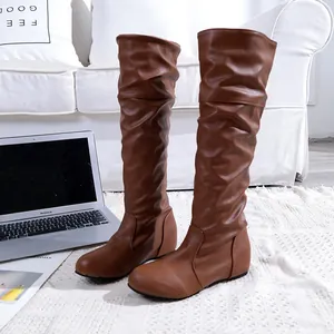 Vue détaillée de bottes hautes plissées marron élégantes avec bout rond.