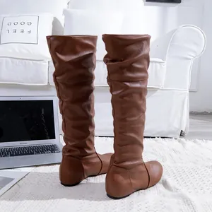 Détail de bottes plissées marron au-dessus du genou en similicuir souple