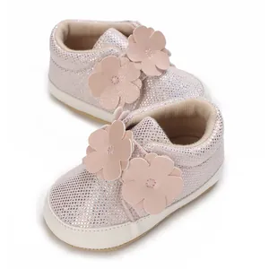 Vue détaillée de chaussures bébé pailletées roses avec fleurs décoratives mignonnes
