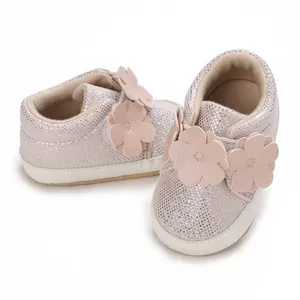 Vue macro détaillée de chaussures bébé à paillettes roses avec semelles souples et fleurs