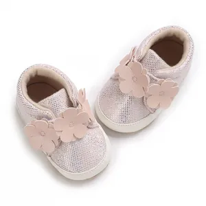 Détail de chaussures de bébé roses pailletées avec appliques de fleurs 3D et semelles souples