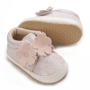 Détail de baskets pailletées roses pour bébé avec fleurs et semelle souple