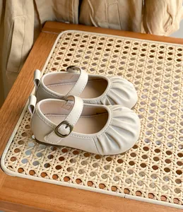 Gros plan de chaussures Mary Jane pour bébé beige avec bout plissé et cuir souple
