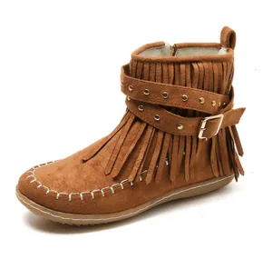 Détail de bottines en daim marron avec franges et lanières à boucles ornées de clous.