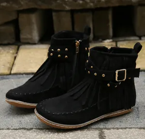 Gros plan de bottines en daim noir avec franges et boucle dorée à clous décoratifs