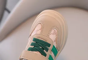 Gros plan détaillé du bout d'une chaussure de marche beige avec lacets verts et motif d'ours