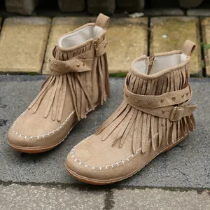 Vue détaillée de bottines en daim marron avec franges et lanière à boucles rivetées