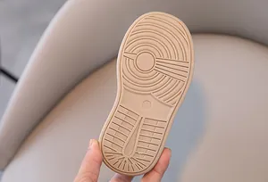 Gros plan de la semelle de chaussure bébé beige avec motif antidérapant et taille 24/170
