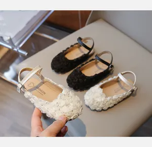 Close-up of elegant white girls' sandals with 3D flower decorations and ankle strap
