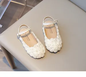 Macro detail of white 3D floral embellishments on elegant girl's princess shoes