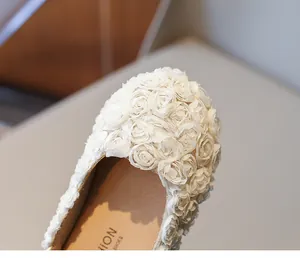 Exquisite close-up of delicate white fabric roses on stylish girls' princess ballet flats