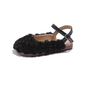 Detailed side view of elegant black girls' sandals featuring 3D floral rose decorations.