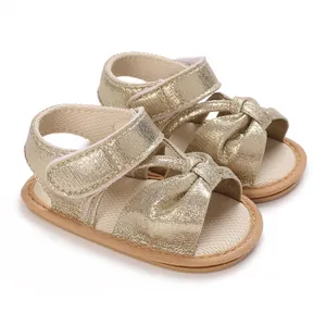 Close-up view of golden glitter baby girl sandals featuring a bow knot and soft non-slip sole