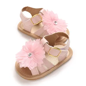 Detalle de sandalias para bebé niña con flor de pétalo rosa y decoración de strass brillante