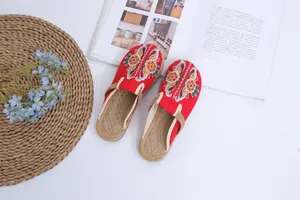 Detailed view of handmade red embroidered ethnic mules with straw woven texture footbed